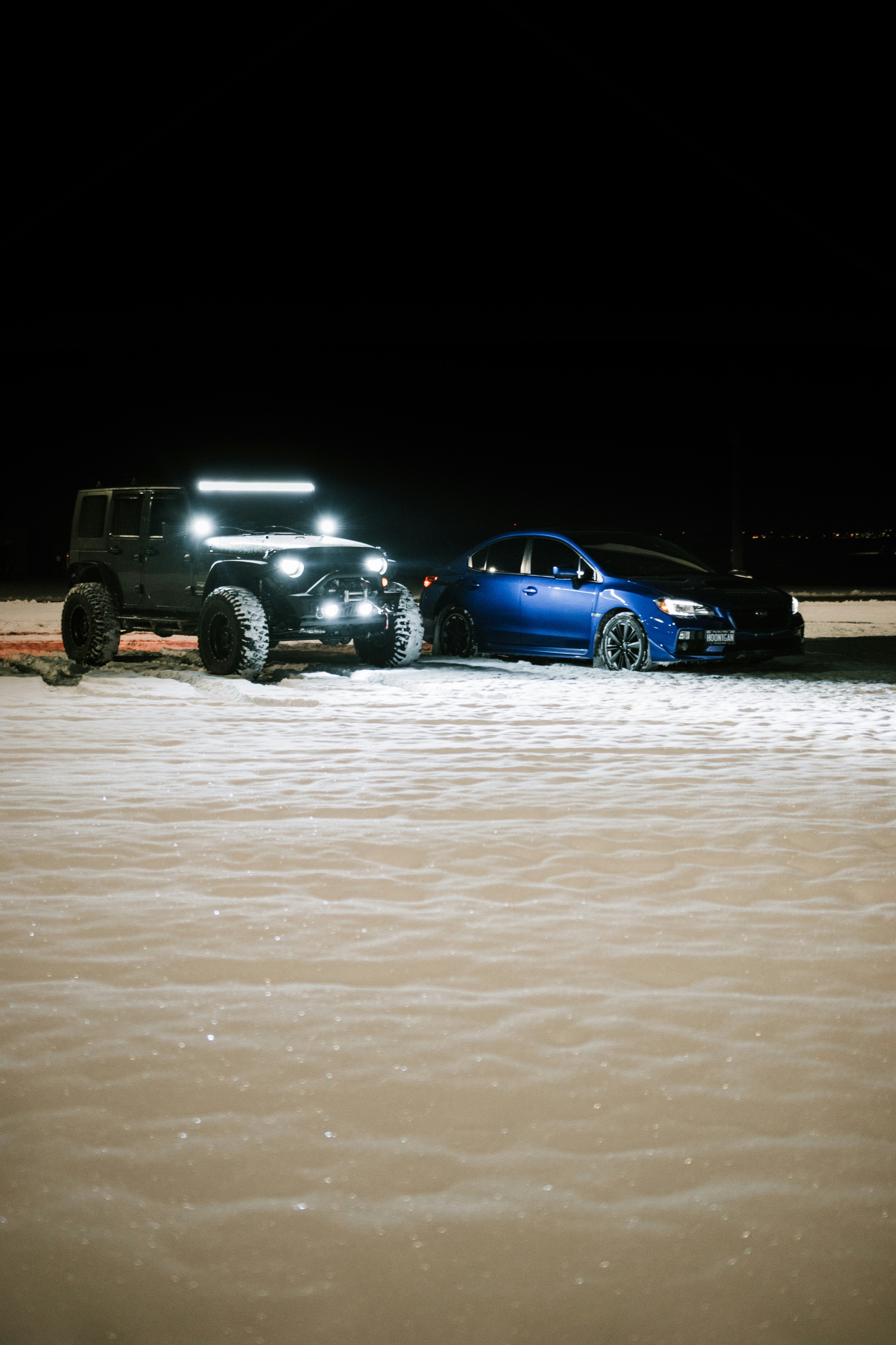 blue chevrolet camaro on snow covered ground during night time